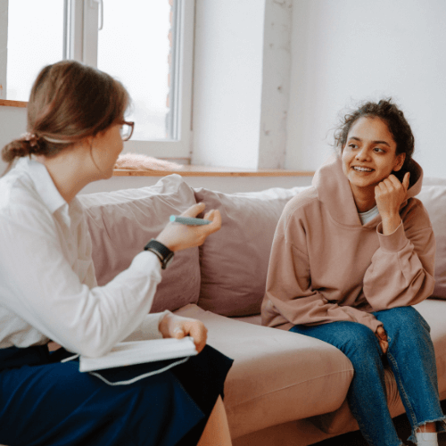 Two women talking on a sofa