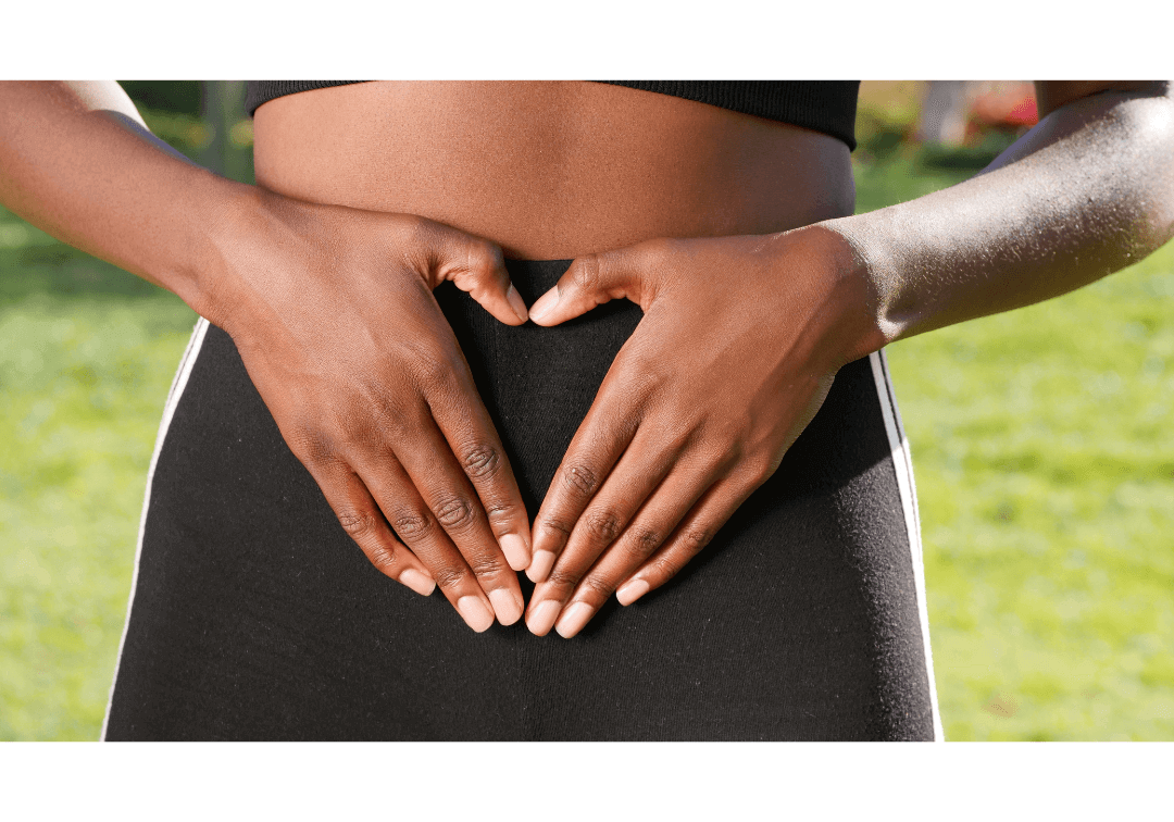 Woman holds palms in heart shape over womb